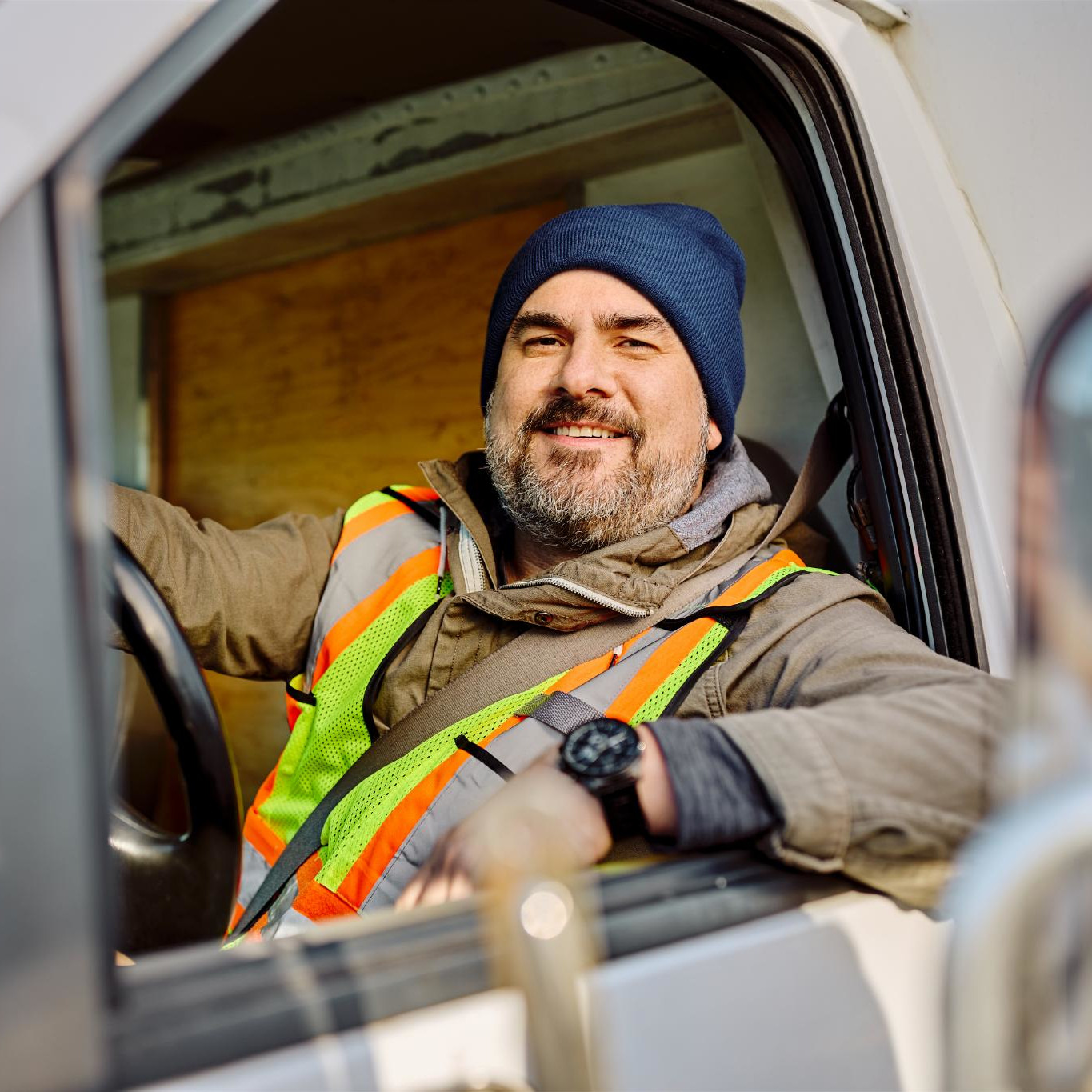 happy-truck-driver-sitting-in-vehicle-cabin-and-lo-2024-12-13-18-40-12-square